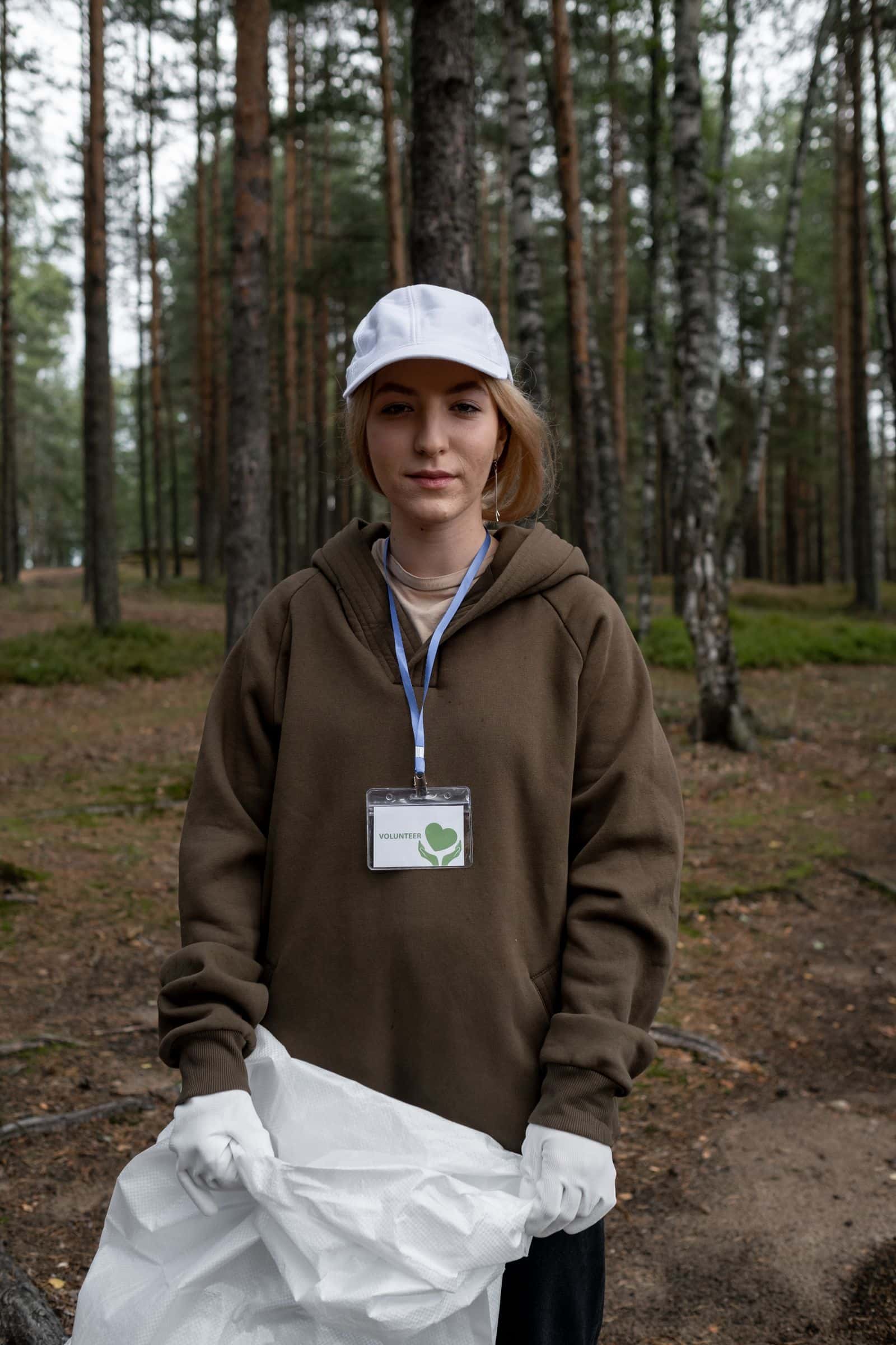 Bénévole souriant ramassant des déchets en forêt